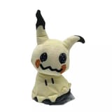 Peluche de Mimikyu visto de frente con la etiqueta de papel visible en la base.