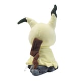 Vista posterior del peluche de Mimikyu mostrando su cola marrón en zigzag.