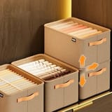 Cajas organizadoras de ropa apiladas con flechas indicando movimiento.