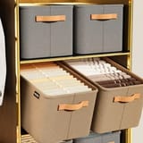 Estantes de clóset con cajas organizadoras grises y beige con ropa.