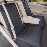 Funda instalada en el asiento trasero con el apoyabrazos central desplegado.