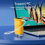 Microscopio amarillo de pie sobre una mesa, conectado con un cable blanco a un notebook abierto