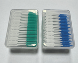 Vista frontal de dos cajas transparentes cerradas, una con cepillos de cerdas verdes y otra azules