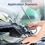 Hombre inclinado sobre el motor abierto de un auto, sosteniendo la sonda del endoscopio, con el teléfono apoyado sobre el motor mostrando la imagen del interior.