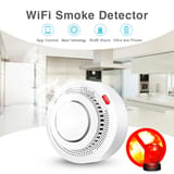 Detector de humo en primer plano con humo ingresando en un entorno de cocina.