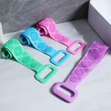 Cuatro fajas de silicona para baño en tonos verde, celeste, rosado y lila sobre una mesa.