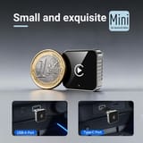 Mini adaptador comparado con una moneda de un euro y conectado a puertos USB-A y Type-C del auto.
