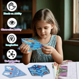 Niña manipulando y doblando un avión de papel decorado sobre una mesa.