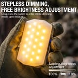 Mano con guante sosteniendo la lámpara encendida con luz cálida, con el panel de LED hacia arriba.