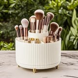 Organizador de cosméticos con base estriada y patas doradas sobre una mesa al aire libre.